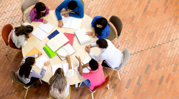 Scholars collaborating around academic materials